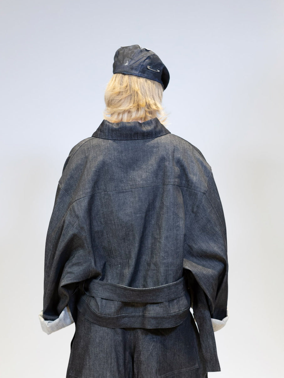 Back view of the ELI 'Juggernaut' heavy denim jacket, highlighting its oversized fit and belt detail at the waist.