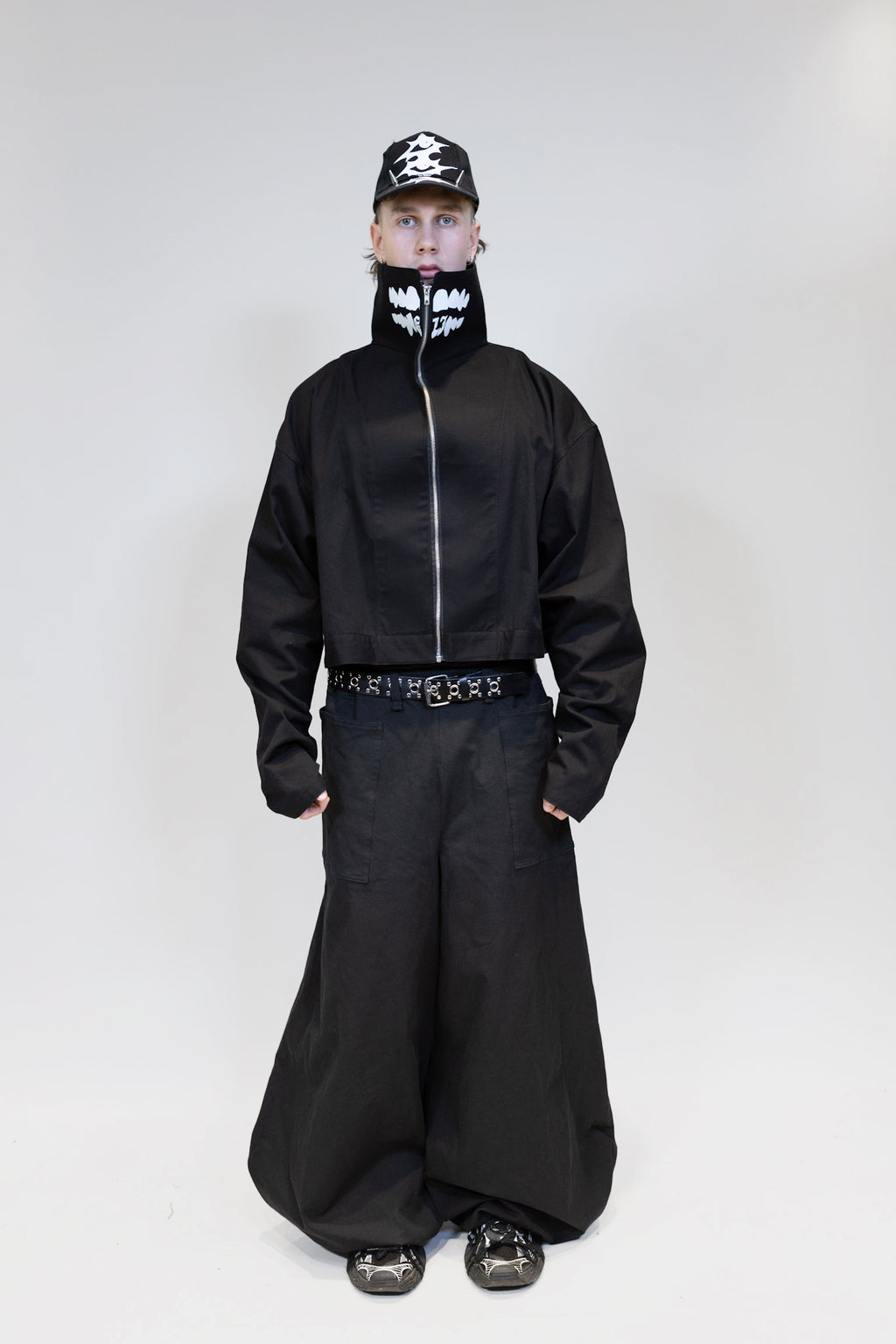 fullbody picture of a male model wearing eli windshield jacket with nikkabokka pants from the front