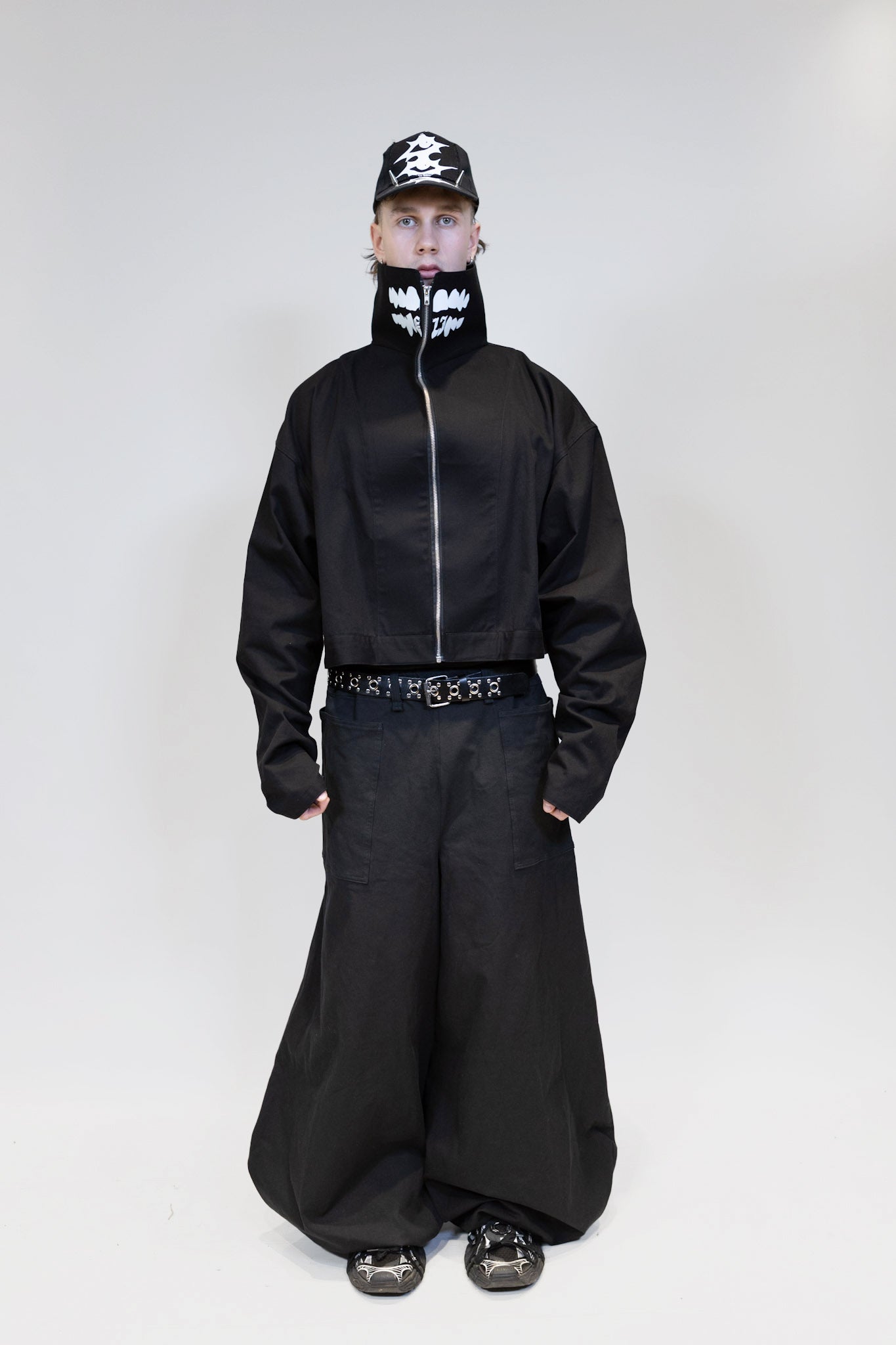 fullbody picture of a male model wearing eli windshield jacket with nikkabokka pants from the front