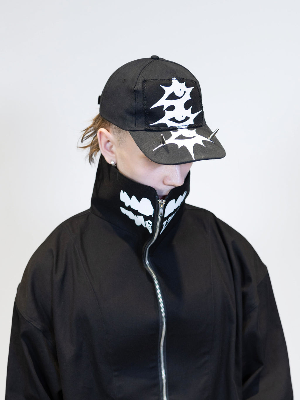 male model wearing eli windshield jacket and eli cap with prints from the front