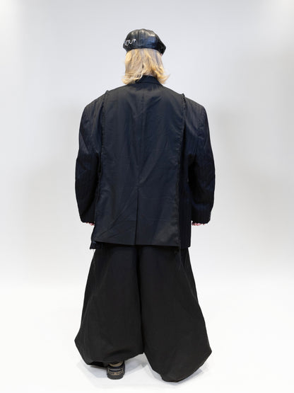 fullbody picture of a female model wearing elieffekt double blazer with eli nikkabokka pants from the back