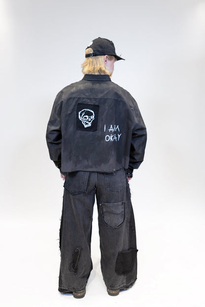 fullbody picture of a female model wearing elieffekt multipocket black baggy denim jeans from the back and a tar shirt